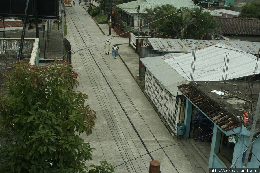 Здесь нет асфальта — здесь везде бетон, а по дороге идут две старые бабушки-гарифунки Ливингстон, Гватемала