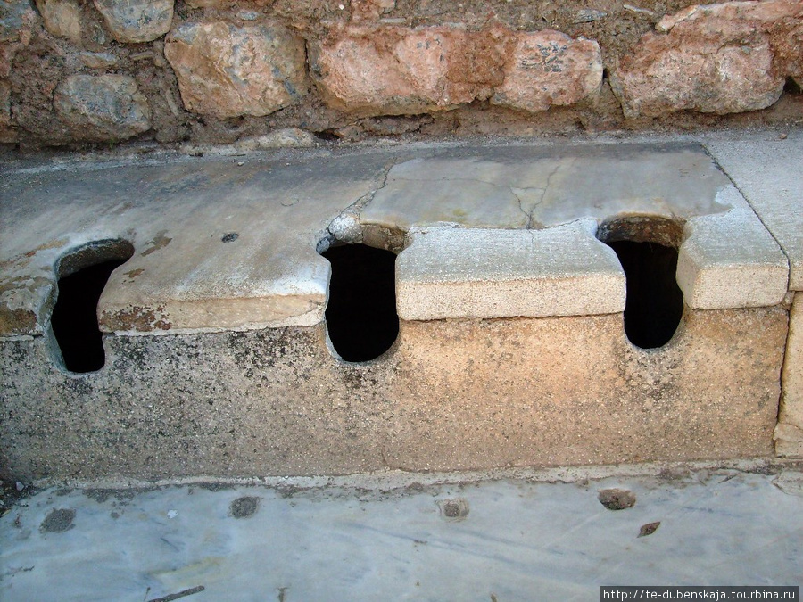 Мраморные сидения туалетов. Узкий водный канал перед унитазами обеспечивал воду для мытья сидящих на них людей. Эфес античный город, Турция