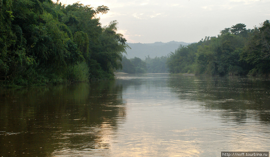 А вот вид из нашего номера, где мы ночевали в этот день.
Здесь река Квай похожа на реку Кинель. Такая же грязная и с быстрым течением. Я в ней купался. Вроде никакой живности обнаружено не было. Хотя спускаться в эту коричневую тропическую речку достаточно боязно. Особенно когда уже смеркается.) Канчанабури, Таиланд