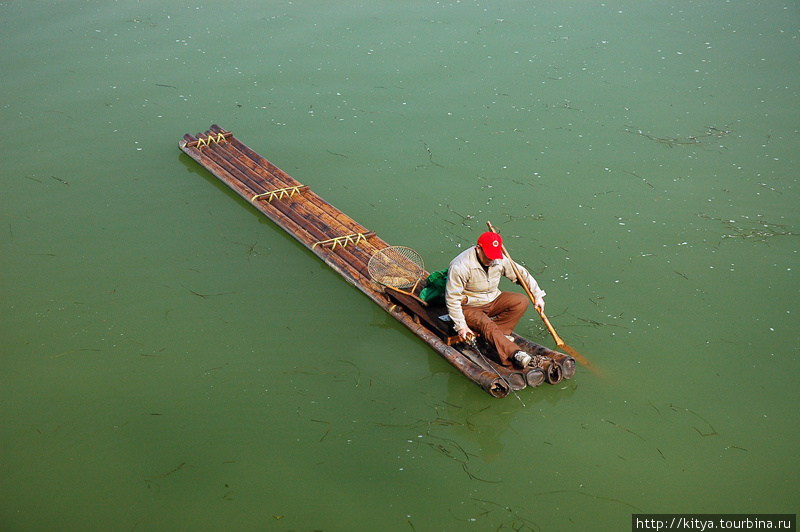 Местный житель на бамбуковом плоту Гуйлинь, Китай