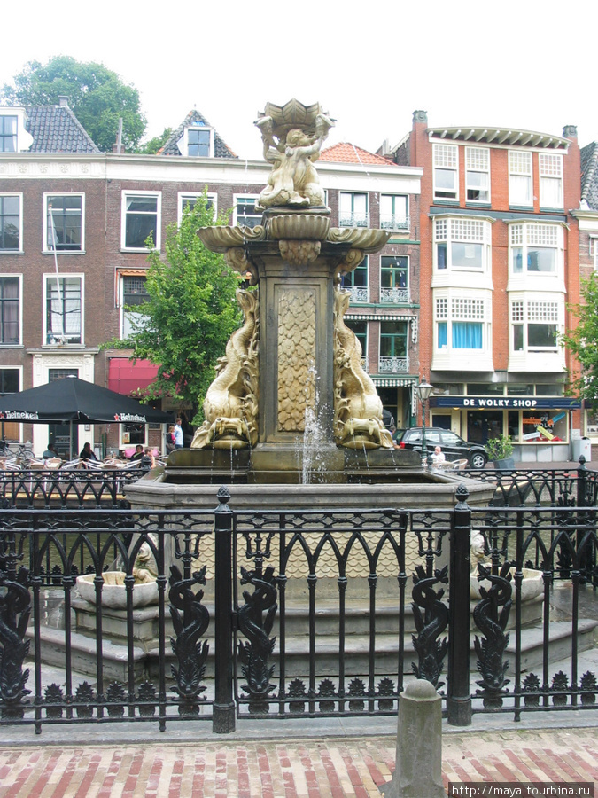 Сверкают позолотой чудовища на старом фонтане. Лейден, Нидерланды