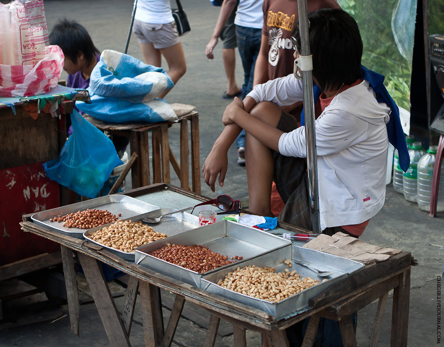 Ещё одно частопродаваемое уличное блюдо — орехи: арахис и кешью. Готовят их тут огромным количеством способов: жарят, варят, добавляют чеснок, лук, перец, соль, сахар, а потом все это рассыпают по небольшим порционным бумажным пакетикам (лежат на столе с краю) Манила, Филиппины