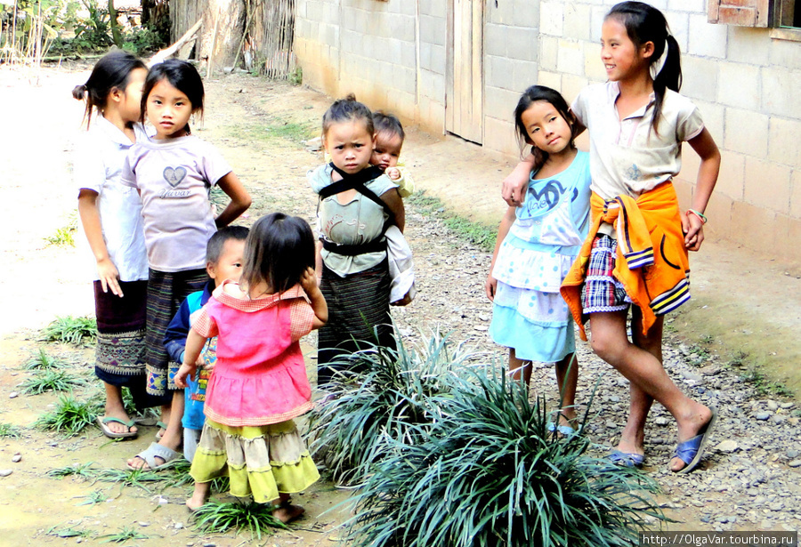 Все вместе тусуются во дворе — и совсем маленькие, и уже почти барышни... Провинция Луангпрабанг, Лаос