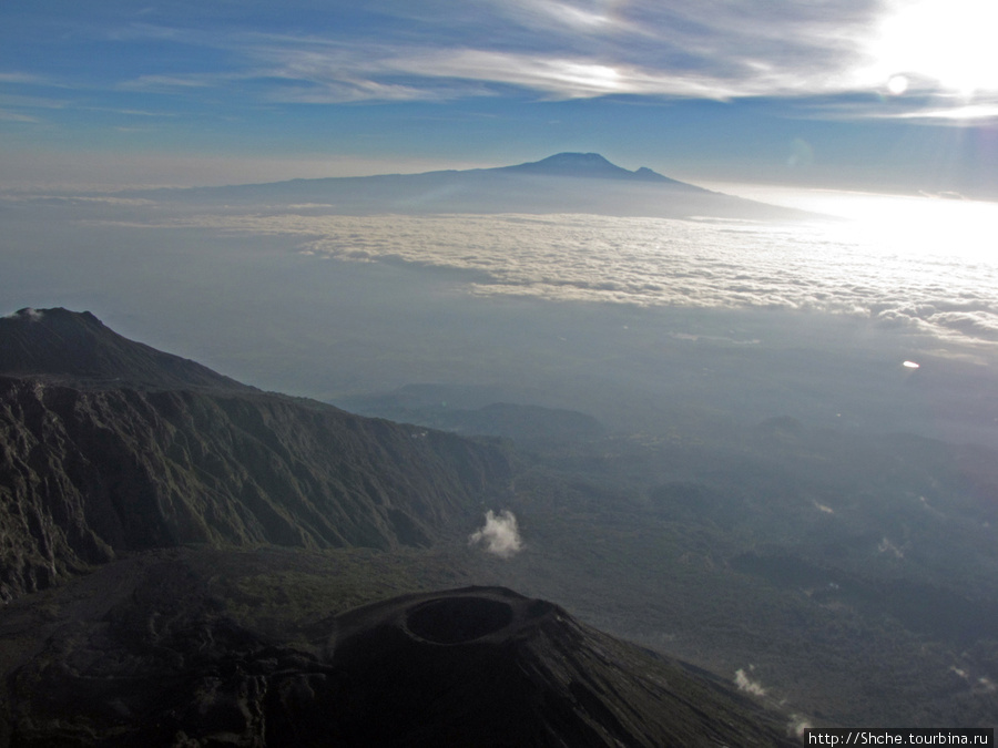 на уровне облаков хорошо видать Килиманджаро -над, нац. парк Аруша — под, новый кратер рядом. Аруша Национальный Парк и гора Меру (4566м), Танзания