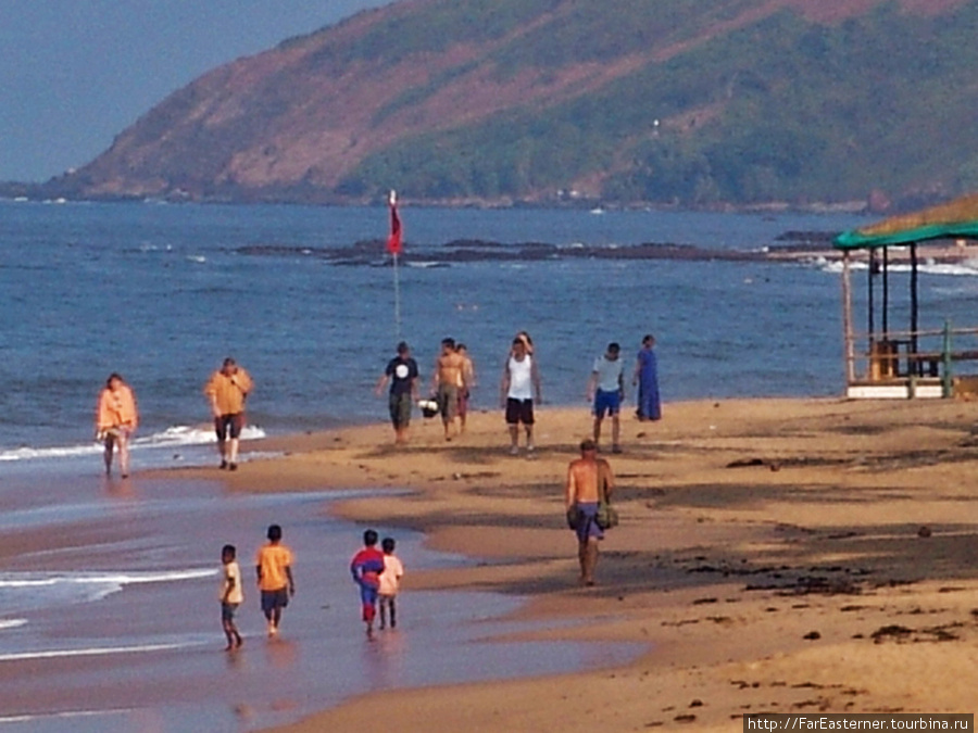 Местные детишки, жители и туристы на пляже Анжуны. Анжуна, Индия