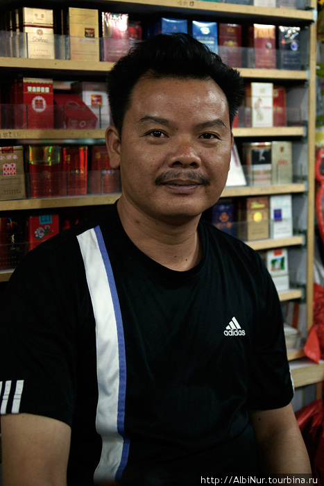 Продавец в мелком магазине, Лунггань. 
 — Спасибо за фотографию, держи пачку сигарет в подарок. Китай