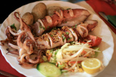 типичная тарелка в ресторанах на Тенерифе — огромная порция морепродуктов или рыбы (в данном случае осьминог), несколько картофелин папас аругадас (запеченные в морской соли) и немного овощного салата