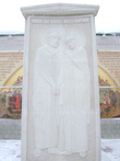 Памятник — стела святым благоверным супругам князю Петру и княгине Февронии Муромским возле монастырской стены