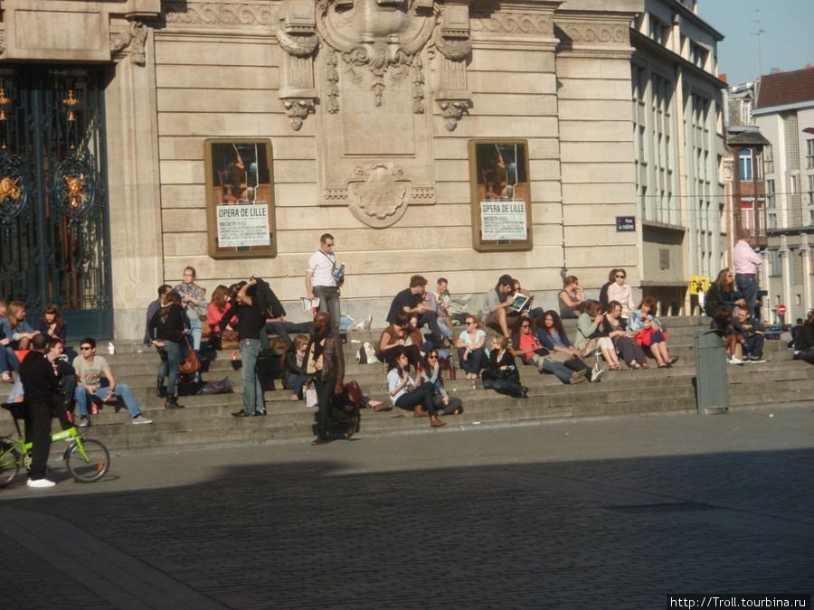 Народ расслабляется на ступенях городского театра Лилль, Франция