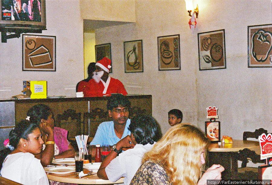 Люди обедают в Пицца Хат в Понди, штат одет как Санта Клаусы Пондишери, Индия