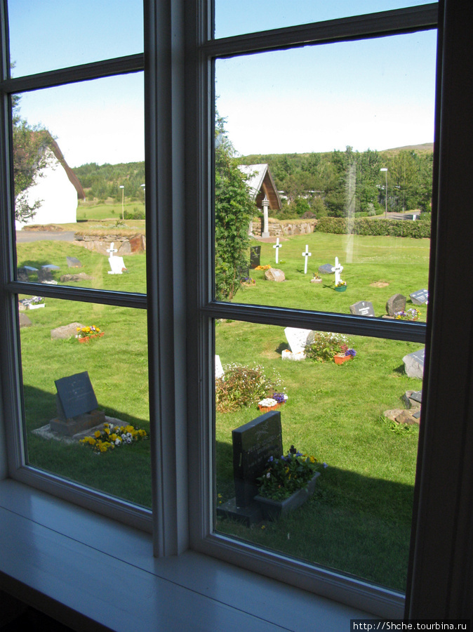 из окна церкви видно старое кладбище Рейкхольт, Исландия