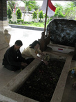 Местные жители кладут лепестки цветов на могилу