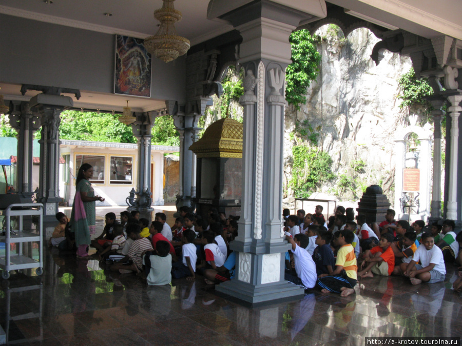 Какие-то школьники индуистского вида, которым тётка что-то рассказывает — может быть, экскурсия от школы? — у ворот Бату Кейвз в небольшом храме Куала-Лумпур, Малайзия