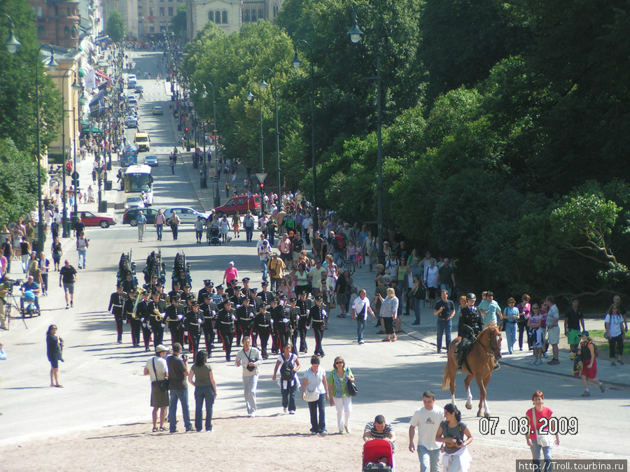 Вид на улицу от королевского дворца, в центре марширует королевская гвардия Осло, Норвегия
