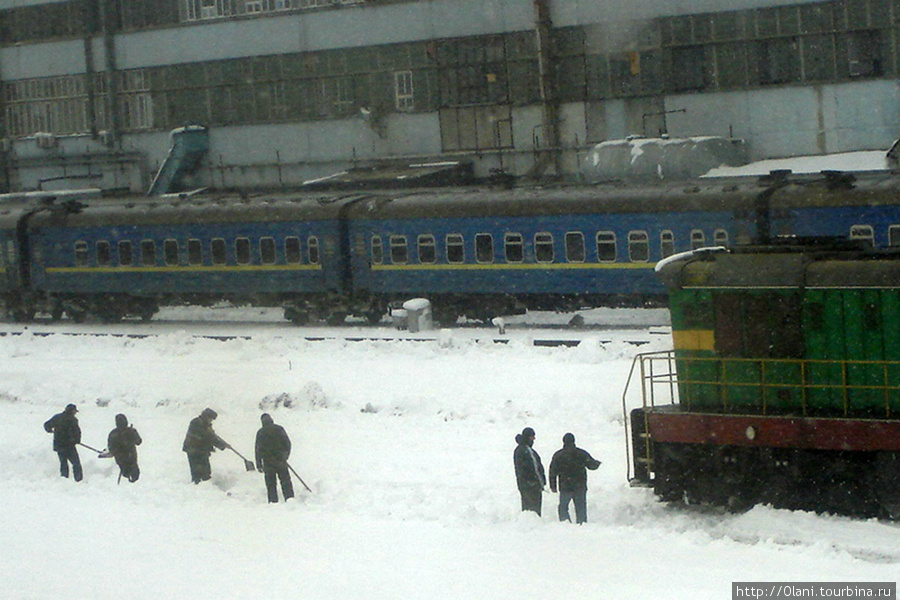 Как-то попали в Киев в снегопад. Поезд задерживали на 6 часов. Перед медленно движущемся поездом идет бригада рабочих и расчищает снег Киев, Украина