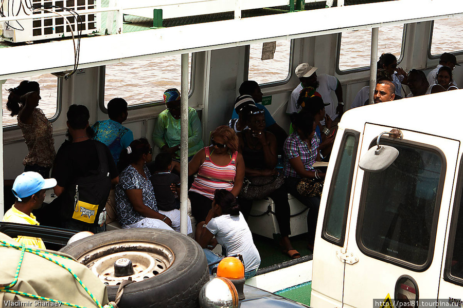 Пассажиры сидят вдоль бортов в крытой галерее. Округ Никкери, Суринам