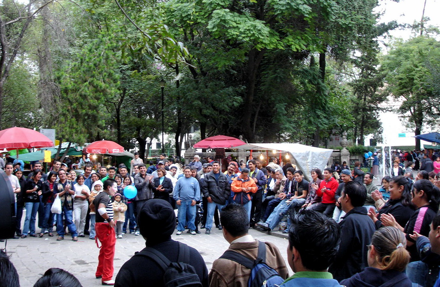 В парке, клоун веселит местных жителей. Мехико, Мексика