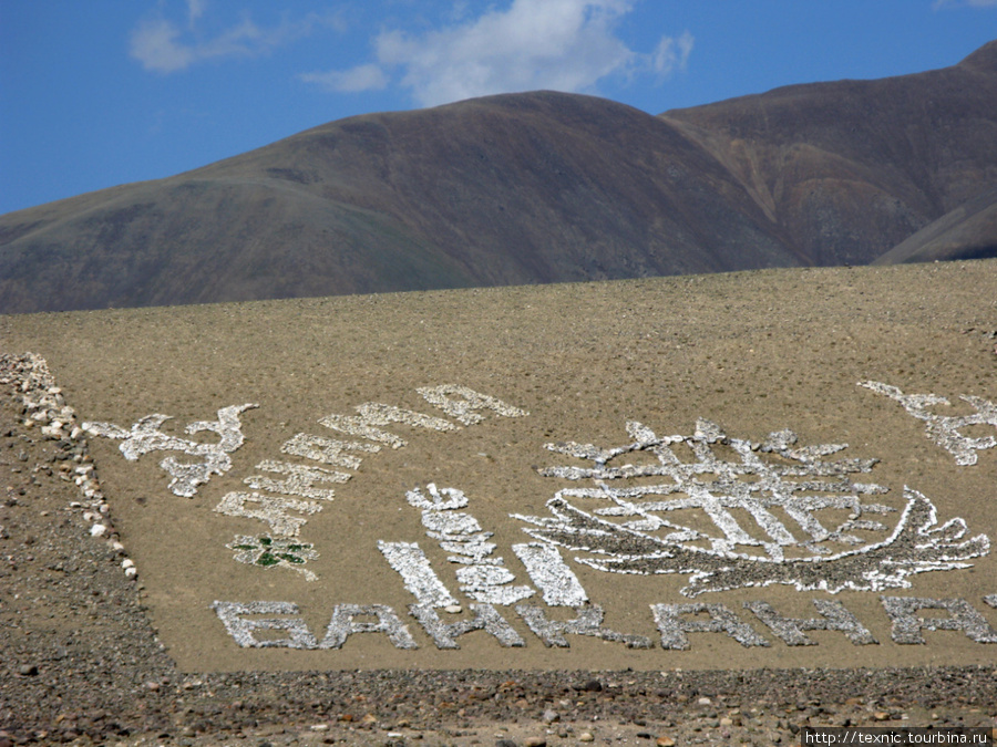 На холме рядом выложены камнями огромные надписи и рисунки. Баян-Улэгэйский аймак, Монголия