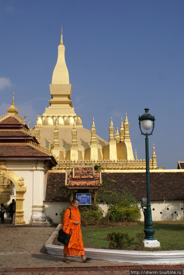 Монах у входа в храм Пха Тхат Луанг во Вьентьяне Вьентьян, Лаос