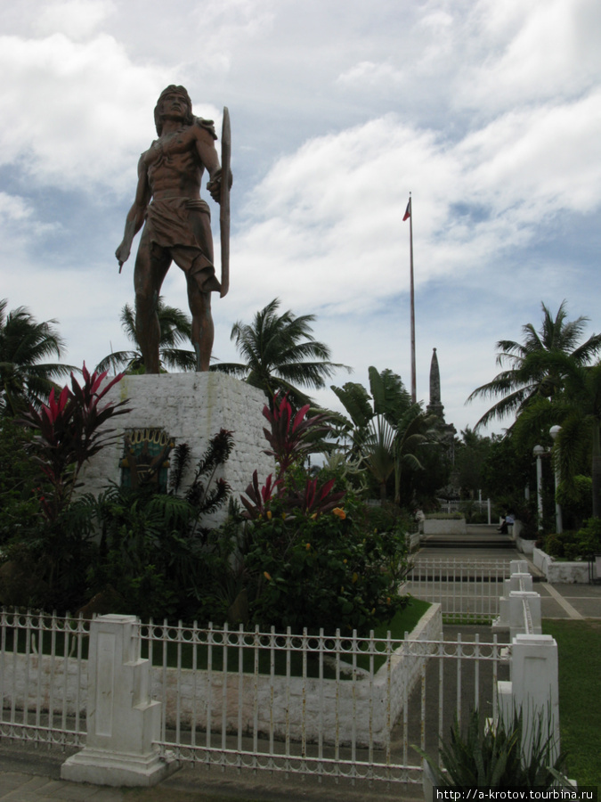 Лапу-Лапу на фоне национального флага Филиппин и могилы убитого им Магеллана Лапу-Лапу-Сити, остров Себу, Филиппины