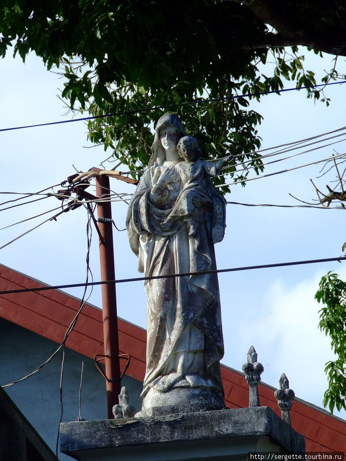 Рядом с Собором есть церковная школа.  Статуя на входе Пуэрто-Принсеса, остров Палаван, Филиппины