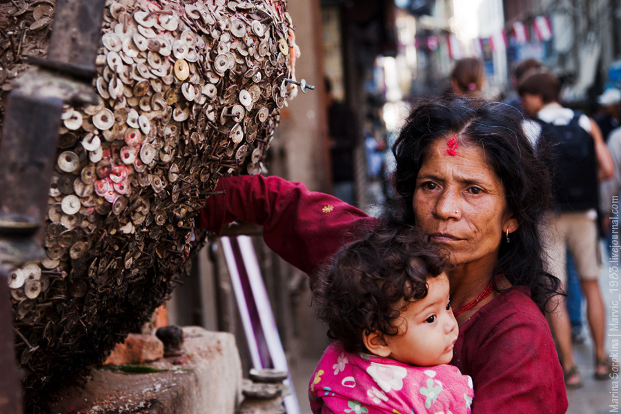 Кроме буддизма в стране очень много приверженцев индуизма. Индуисты могут поставить какую-то вещь, покрасить ее и поклоняться ей. Очень удобно! Вот, к примеру, денежный бог — множество монеток прибитых гвоздями. Они подходят к нему, опускают в его пасть руку, приносят рис, цветы и свечи... Катманду, Непал