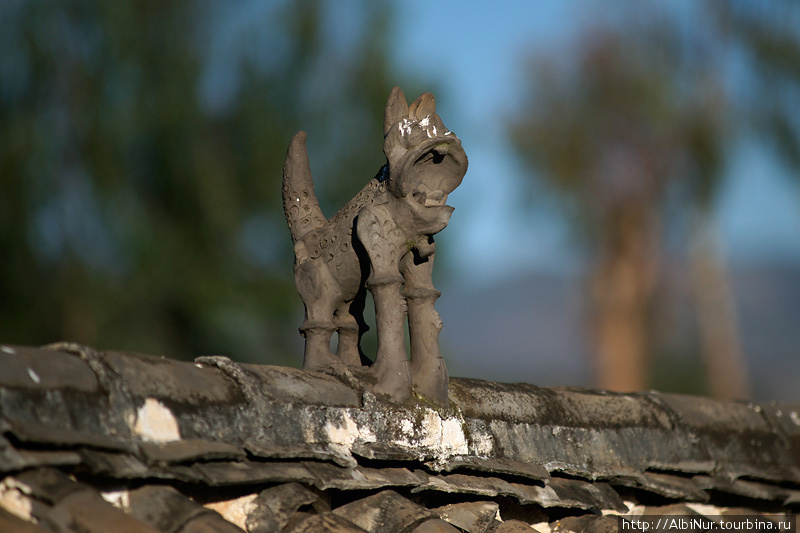 Конус крыши в Юннани традиционно украшают глиняной символической фигуркой тотемного животного. Провинция Юньнань, Китай