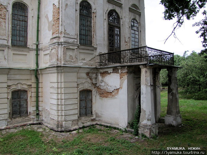Вход в теплую церковь отмечен колоннами, на верху которых устроен балкончик в металлическом ожерелье. Нежин, Украина