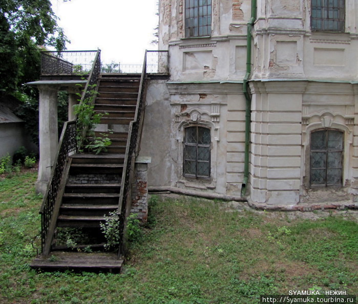 Вход на второй этаж осуществлялся по такой же ажурной лестнице. В настоящее время лестница потеряла несколько ступенек, заржавела и обзавелась деревцем-рябинкой... Нежин, Украина