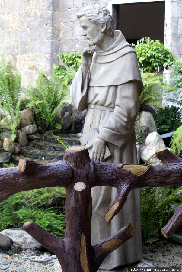 Статуя монаха во внутреннем дворике базилики Санта Нино в Себу Себу-Сити, остров Себу, Филиппины