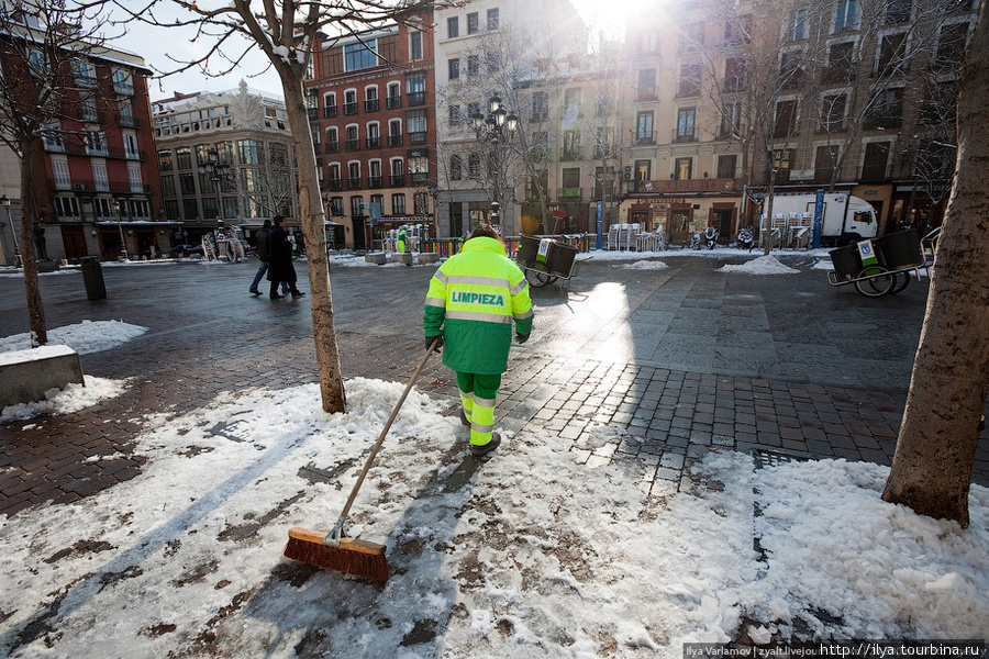 Медленно, но верно снег собирают кучками на площади и оставляют до весны. Мадрид, Испания