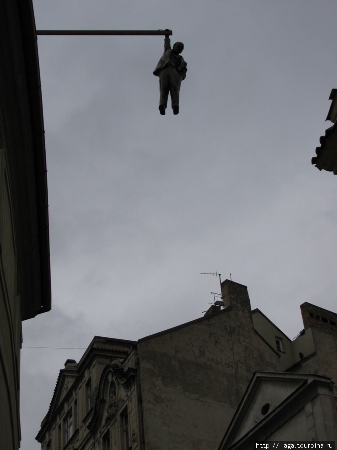 Подвешенный человек весит на балке закрепленной на одном из домов на Гусовой улице. Подвешенный человек» – скульптура Зигмунда Фрейда. Автор работы — современный чешский скульптор Девид Черный. Прага, Чехия