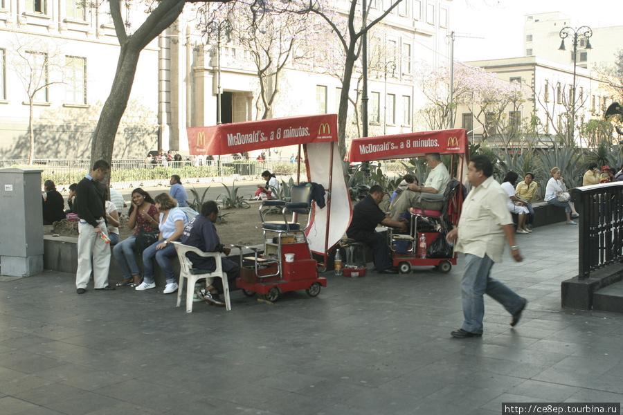 Передвижные кабинки чистильщиков обуви имеют навесы с рекламой МакДональдса Мехико, Мексика