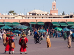 Люди в красных нарядах — это местные водоносы, такой же растиражированный и узнаваемый образ Марокко, как сама площадь. За небольшую мзду они наливают чашку воды желающим попить, нежелающих уговаривают, а туристов разводят на платные фотографии.