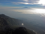 на уровне облаков хорошо видать Килиманджаро -над, нац. парк Аруша — под, новый кратер рядом.