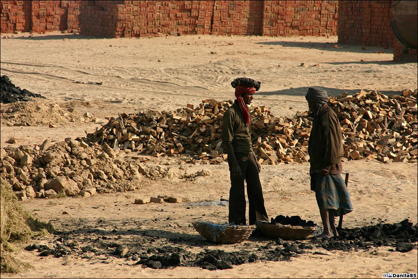 ...который им приносят другие рабочие. На голове у того, что слева подушка для удобства переноски. Штат Пенджаб, Индия