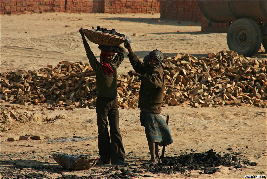 Второй рабочий помогает первому поставить на голову корзину. Штат Пенджаб, Индия