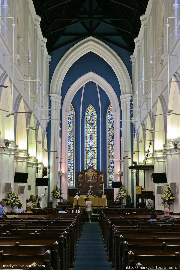 Классическое внутренее убранство собора разбавлено современными плоскими мониторами. Сингапур (город-государство)