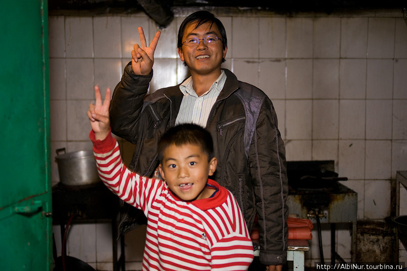 Владелец гестхауза с сыном, Си-Шань. 
 — Будете готовить сами? Всё равно 15 кваев. Китай
