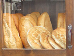 На любой улочке любого турецкого города есть  застекленные шкафы со свежим хлебом. Вот за стеклом пригрелся самый обычны пшеничный батон экмек и плоская пита.
