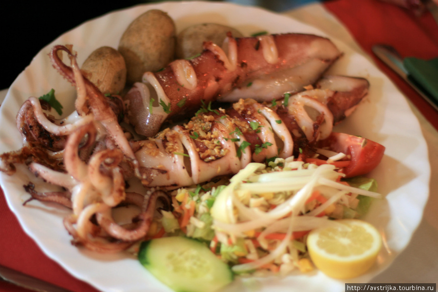типичная тарелка в ресторанах на Тенерифе — огромная порция морепродуктов или рыбы (в данном случае осьминог), несколько картофелин папас аругадас (запеченные в морской соли) и немного овощного салата Остров Тенерифе, Испания