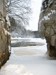 Плотина зимой. Поверхность реки замерзает и только за плотиной, где всегда самый интенсивный поток, можно увидеть проталины.