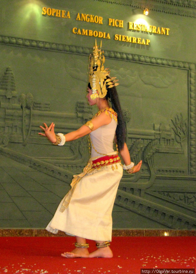 Девушки танцуют с прямым корпусом, вывернутыми наружу ступнями и изогнутыми вверх пальцами слегка согнутых ног Сиемреап, Камбоджа