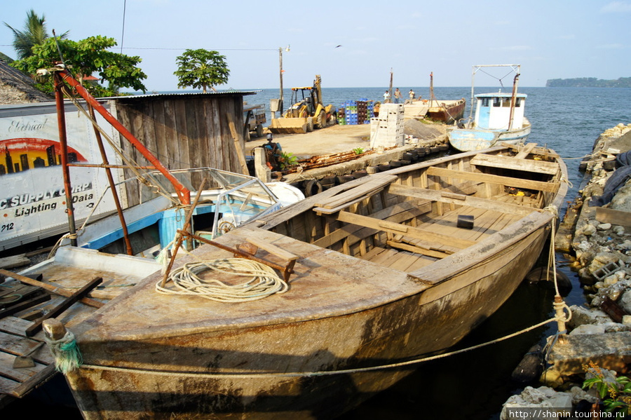 Старая деревянная лодка на берегу Ливингстон, Гватемала