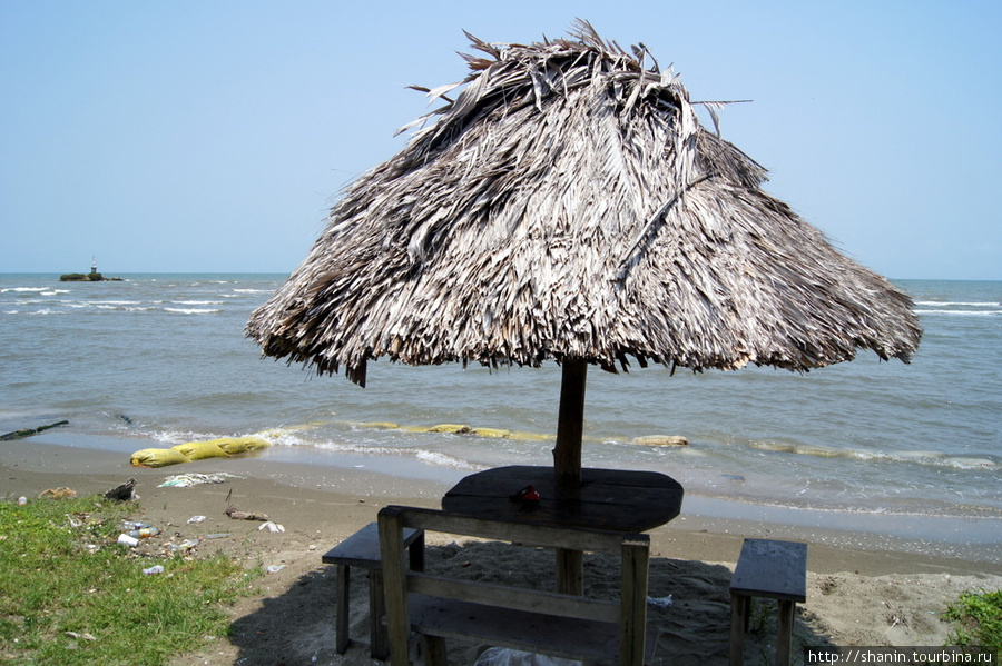 Беседка с соломенной крышей на берегу моря Ливингстон, Гватемала