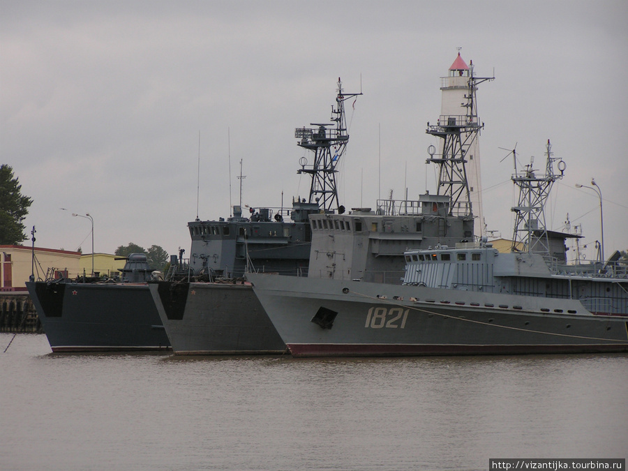 Кронштадт. Военные корабли. За ними виден маяк. Кронштадт, Россия