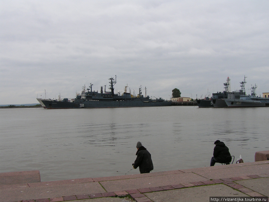 В Кронштадте рыбаки ловят рыбку вблизи военных судов. Кронштадт, Россия