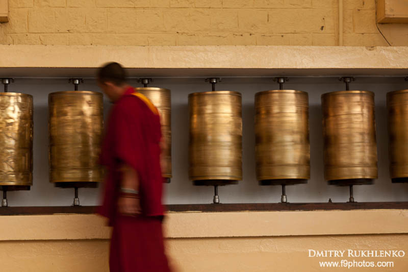 Буддистский монах, идущий мимо молитвенных барабанов. Резиденция Далай Ламы, МкЛеод Ганж, Химачал Прадеш, Индия Маклеод Гандж, Индия