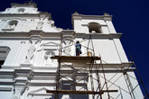 Рабочий красит фасад церкви