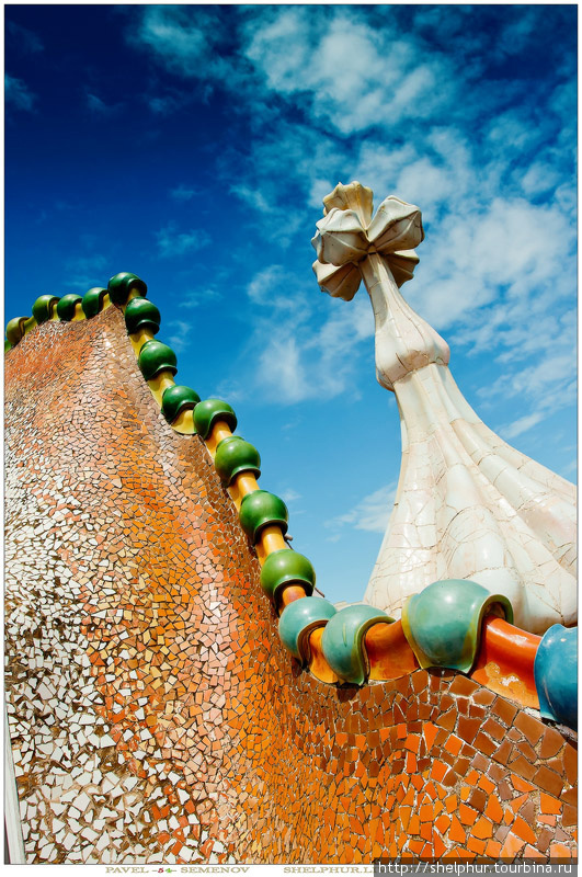 Меч Св. Георгия, вонзённый в «хребет дракона», представлен в виде башенки, увенчанной георгиевским крестом, фасад здания изображает сверкающую «чешую» чудища и усеян костями и «черепами» его жертв, которые угадываются в формах колонн бельэтажа и балконов. Барселона, Испания